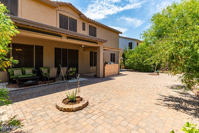 rear view of property featuring outdoor lounge area and a patio area