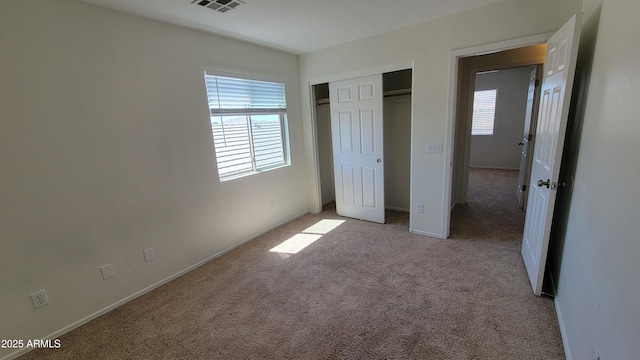 unfurnished bedroom featuring light colored carpet, a closet, and baseboards