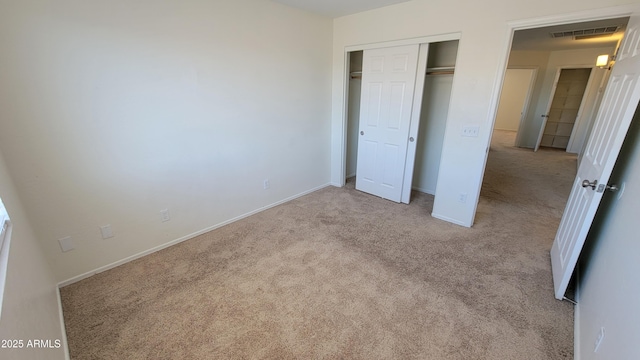 unfurnished bedroom featuring baseboards, a closet, visible vents, and carpet floors