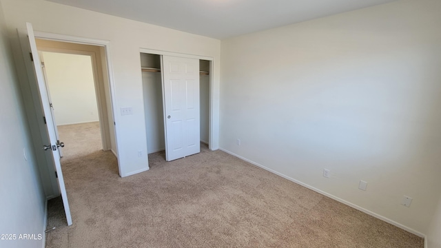 unfurnished bedroom with baseboards, a closet, and carpet floors