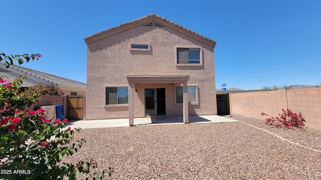 back of property with stucco siding, a fenced backyard, and a patio
