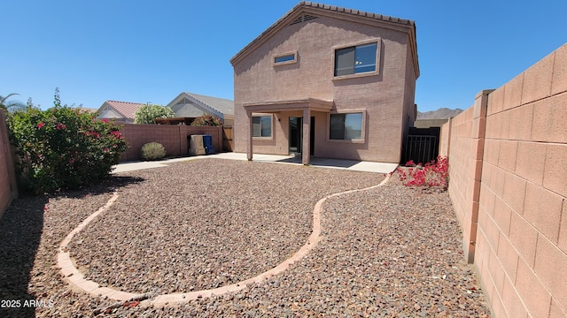 back of property with a patio, stucco siding, and a fenced backyard