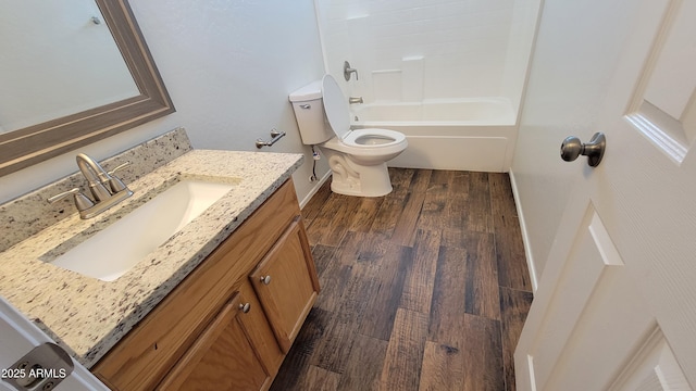 bathroom featuring toilet, wood finished floors, vanity, shower / bath combination, and baseboards