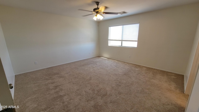 carpeted spare room featuring ceiling fan, baseboards, and visible vents