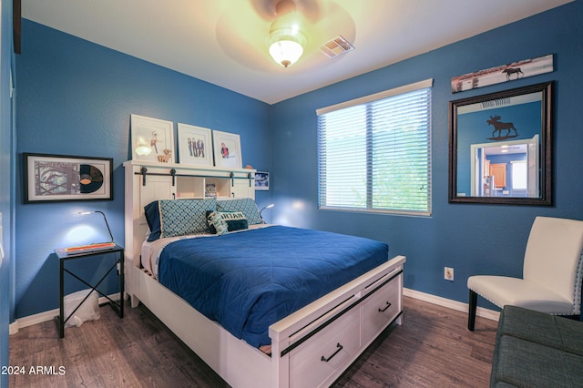 bedroom featuring visible vents, baseboards, ceiling fan, and dark wood-type flooring