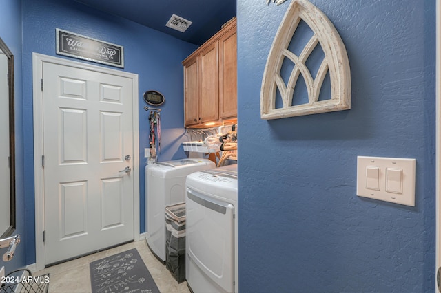 clothes washing area featuring light tile patterned floors, a textured wall, visible vents, cabinet space, and washing machine and clothes dryer