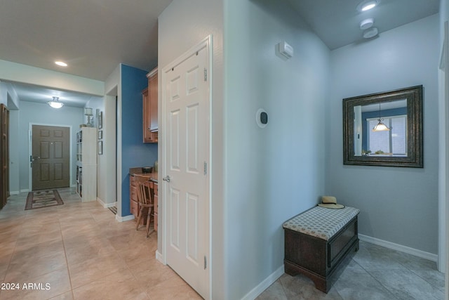 hall featuring light tile patterned floors, recessed lighting, and baseboards