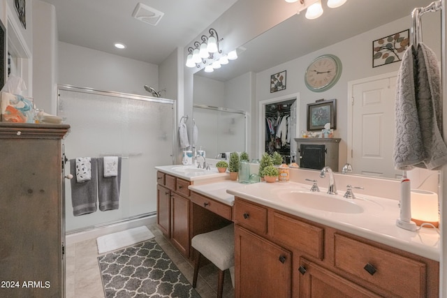 bathroom featuring a spacious closet, a stall shower, and vanity