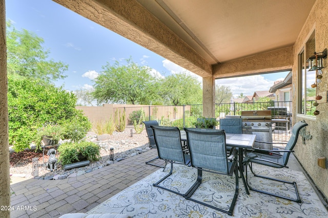 view of patio featuring outdoor dining area, a fenced backyard, and a grill