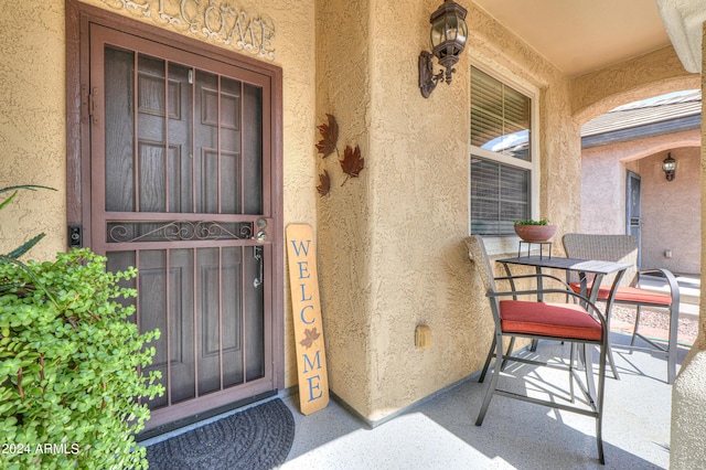 entrance to property featuring covered porch and stucco siding