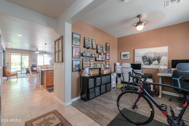 home office featuring light tile patterned floors, ceiling fan, visible vents, and baseboards