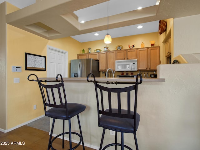 kitchen with a kitchen bar, decorative light fixtures, kitchen peninsula, and stainless steel refrigerator with ice dispenser