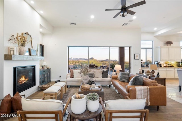 living room featuring a mountain view, light hardwood / wood-style floors, and ceiling fan