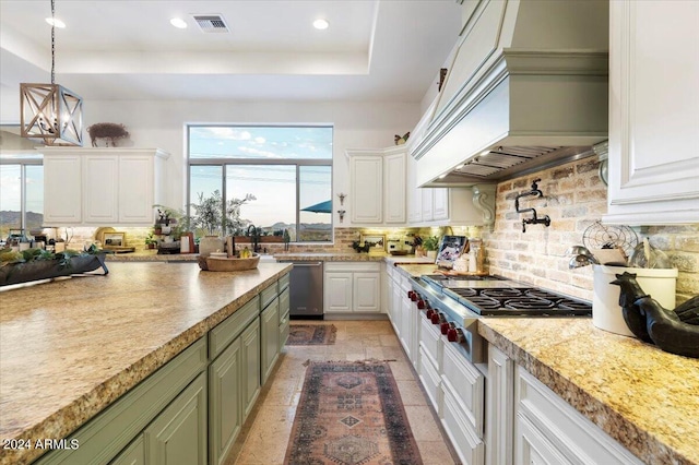 kitchen featuring a wealth of natural light, backsplash, white cabinets, and custom exhaust hood