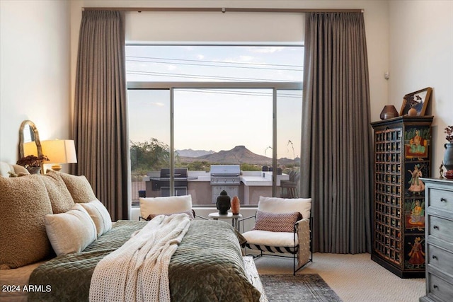 bedroom featuring a mountain view, multiple windows, and light colored carpet