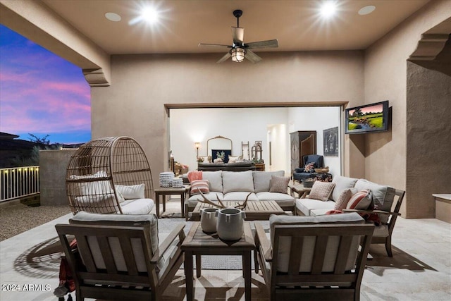 patio terrace at dusk featuring an outdoor living space and ceiling fan