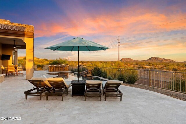 patio terrace at dusk with a mountain view and an outdoor fire pit