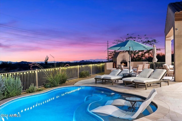 pool at dusk with an outdoor hangout area and a patio area