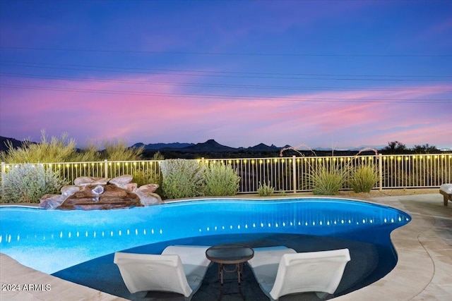 pool at dusk featuring a patio area