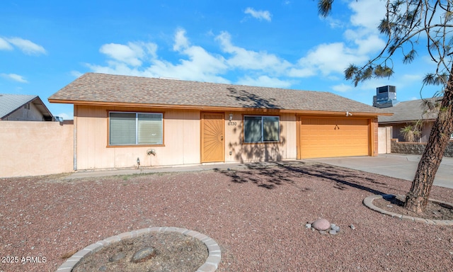 ranch-style house featuring a garage and central AC