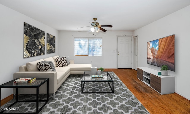 living room with dark wood-type flooring and ceiling fan