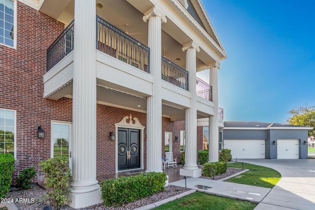 view of exterior entry featuring a porch and a balcony