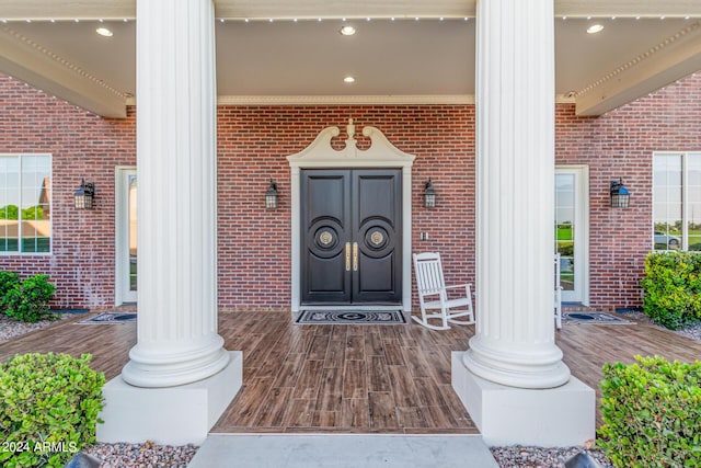 view of exterior entry featuring covered porch