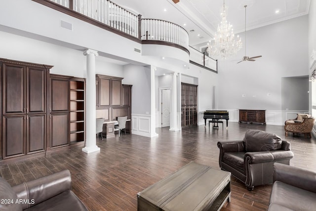 living room featuring dark hardwood / wood-style flooring, a towering ceiling, and ornate columns