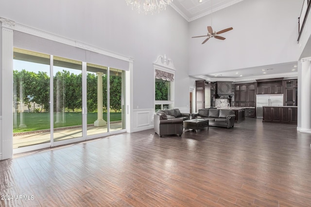 unfurnished living room with dark hardwood / wood-style flooring, a towering ceiling, and a wealth of natural light