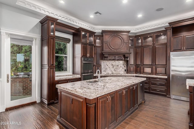 kitchen featuring dark brown cabinetry, dark wood-type flooring, an island with sink, and stainless steel appliances