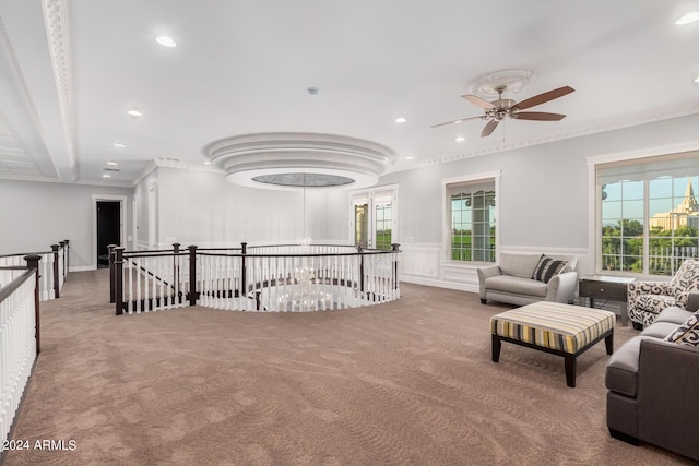 carpeted living room featuring ceiling fan and crown molding