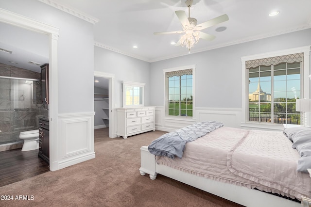 carpeted bedroom featuring ensuite bath, a spacious closet, ceiling fan, a closet, and ornamental molding