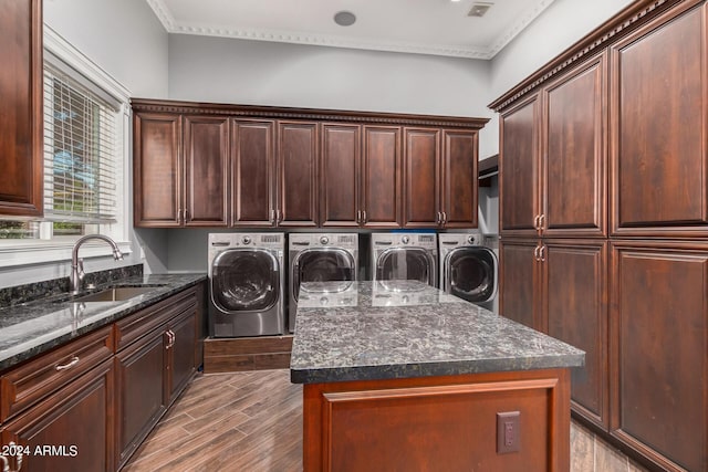 laundry room featuring washer and dryer, light wood-type flooring, cabinets, and sink