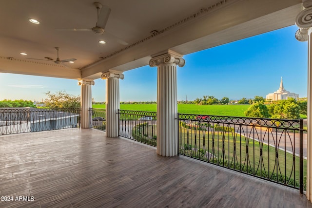 wooden terrace featuring ceiling fan, a yard, and covered porch