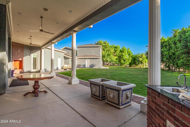 view of patio featuring ceiling fan and sink