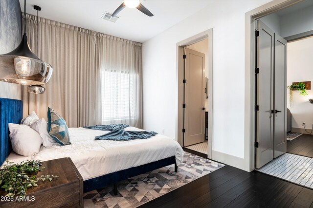 bedroom with a ceiling fan, baseboards, visible vents, and hardwood / wood-style floors