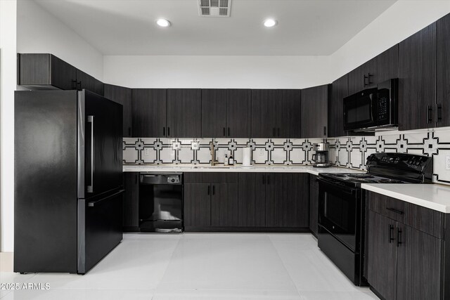 kitchen featuring black appliances, tasteful backsplash, light countertops, and visible vents