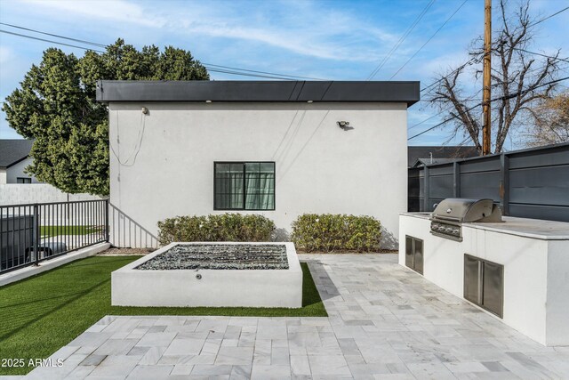 view of patio / terrace featuring a grill, area for grilling, and fence