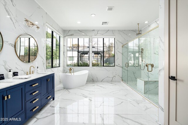 full bathroom with marble finish floor, a sink, a marble finish shower, and stone wall