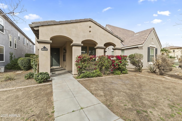 view of front of house featuring a tiled roof and stucco siding