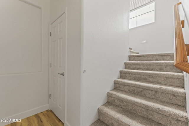 staircase with wood finished floors and baseboards