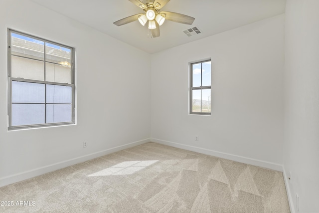 spare room featuring carpet, visible vents, and baseboards