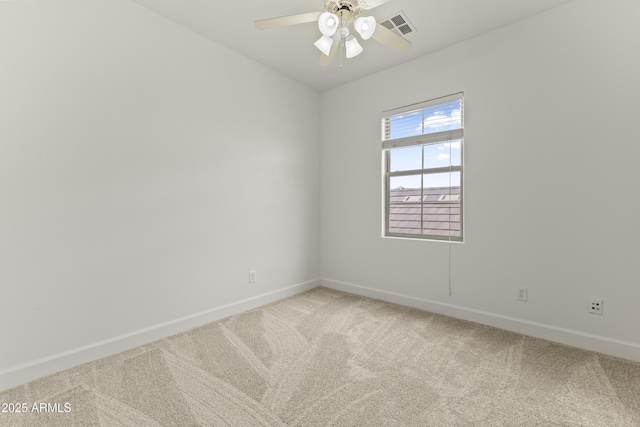 empty room with light carpet, a ceiling fan, visible vents, and baseboards