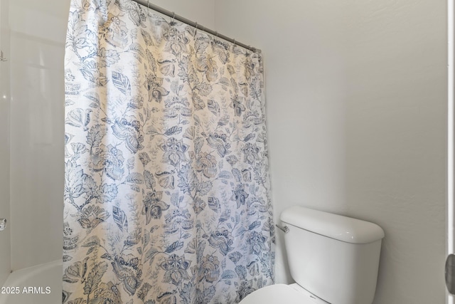 full bath featuring toilet and curtained shower