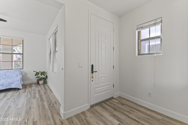 foyer entrance with light wood-style floors and baseboards