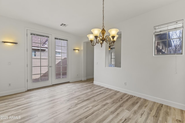 unfurnished dining area featuring a wealth of natural light, visible vents, and wood finished floors