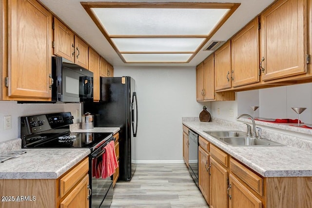 kitchen with light wood-type flooring, sink, and black appliances