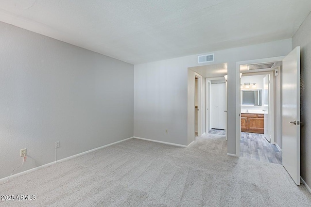 empty room featuring light colored carpet and a textured ceiling