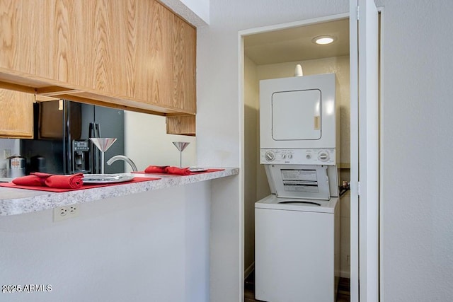 washroom featuring stacked washer / dryer and sink