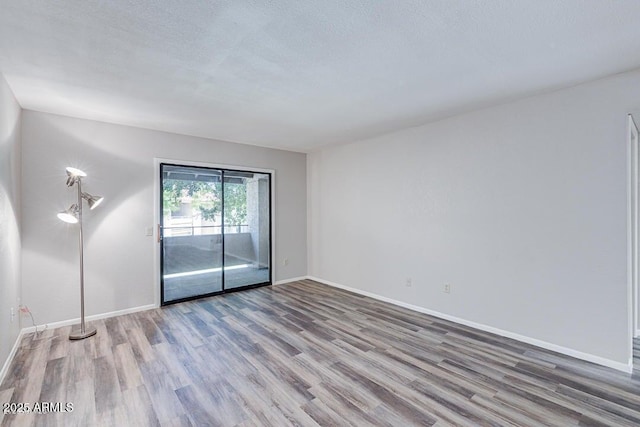 spare room with light hardwood / wood-style floors and a textured ceiling